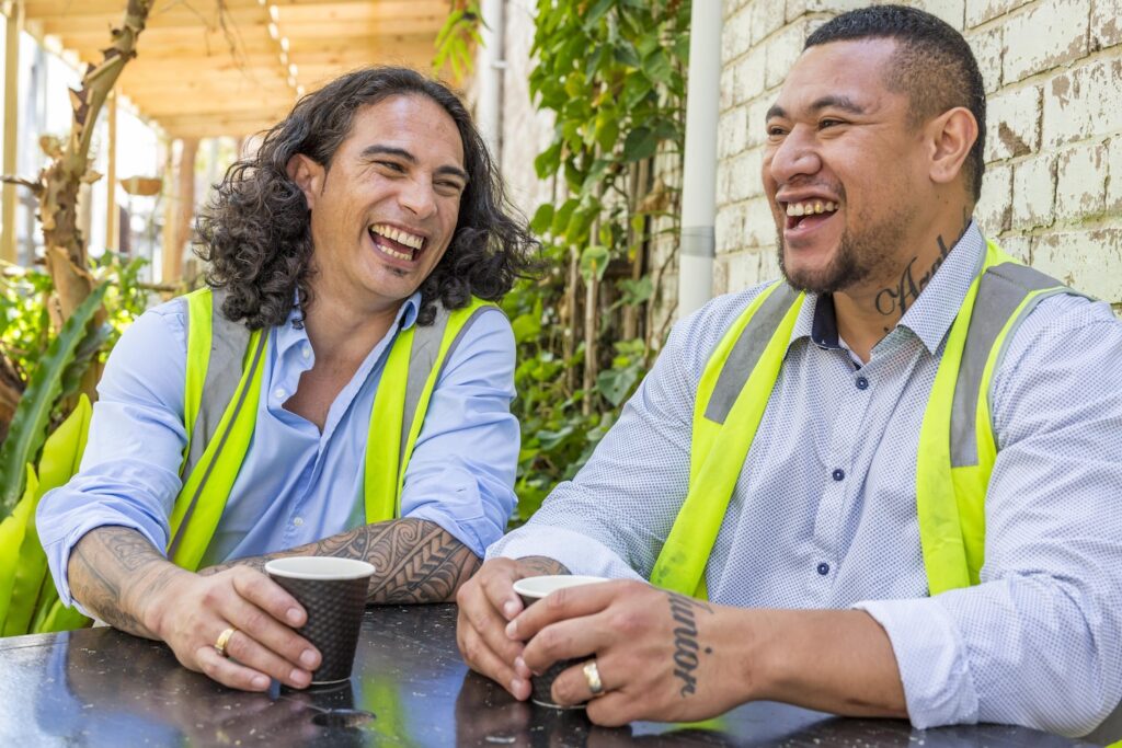 Two Polynesian men laughing